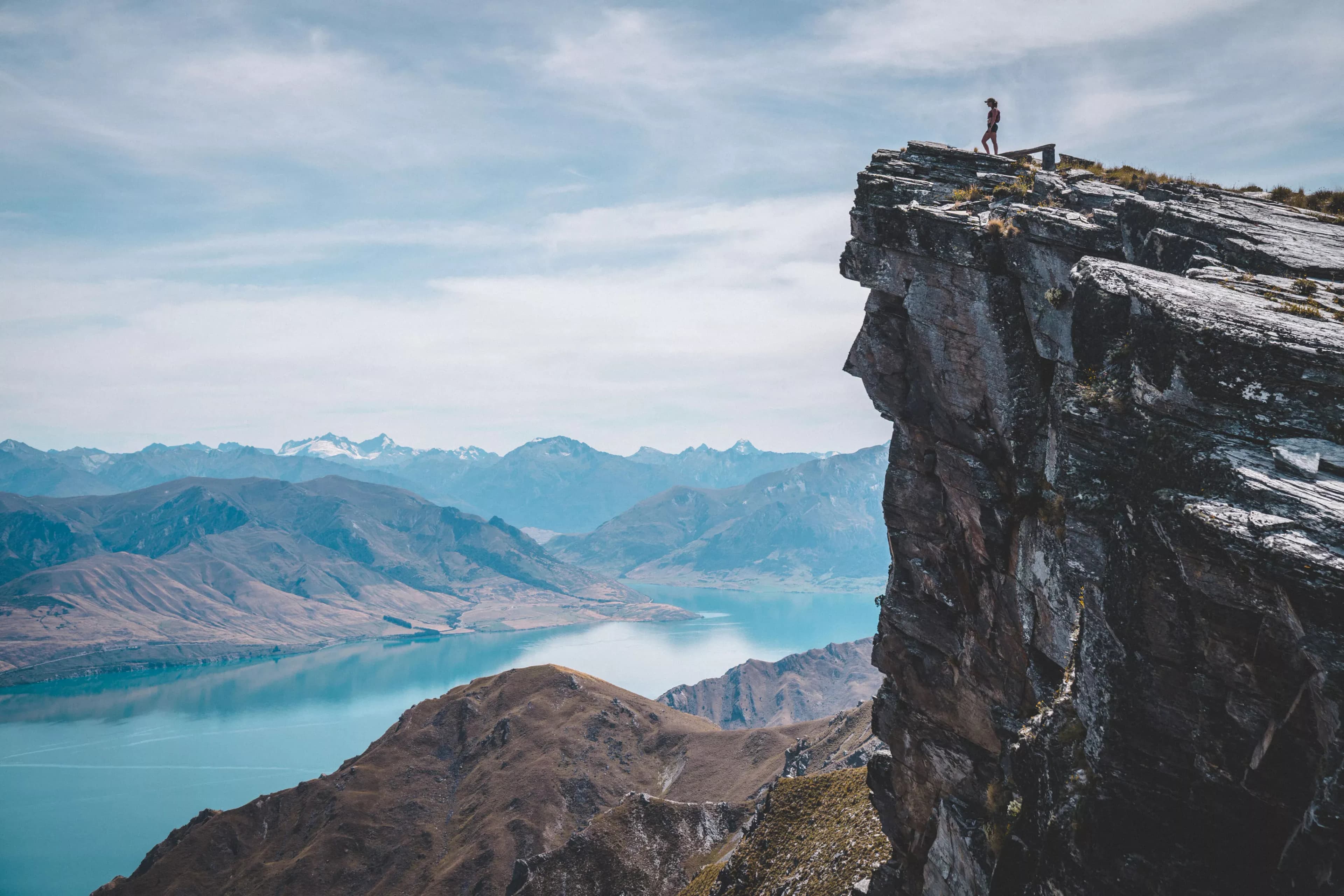 Hiker on Breast Hill overlooking Lake Hāwea, New Zealand.